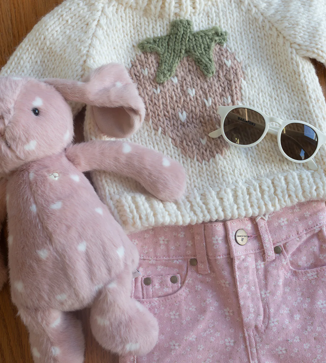 A hand-knit strawberry sweater, pink floral jeans, a pink bunny plush and cream Babiators sunglasses, from Hildreth’s in Southampton