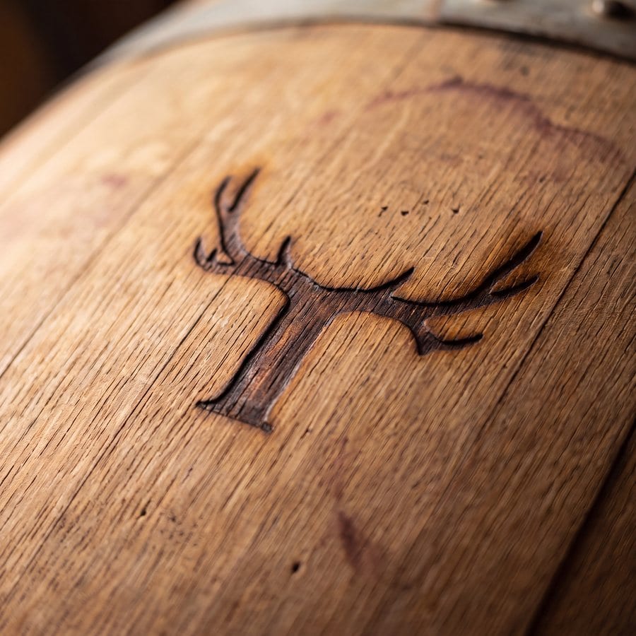 Theo Vineyard antler logo carved into a wine barrel